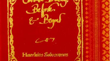 A sample cover of the book: red coloured handloom sari with gold embossed nameplate and lettering for the title and author's name. The border of the sari lines the right hand margin of the cover.