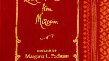 A sample cover of the book: dark red coloured handloom sari with gold embossed nameplate and lettering for the title and author's name. The border of the sari lines the right hand margin of the cover.