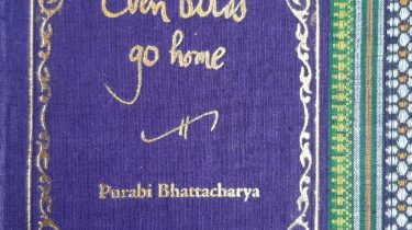 A sample cover of the book: Indigo-blue handloom sari with gold embossed nameplate and lettering for the title and author's name. The border of the sari lines the right hand margin of the cover.