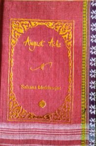 A sample cover of the book: salmon coloured handloom sari with gold embossed nameplate and lettering for the title and author's name. The border of the sari lines the right hand margin of the cover.
