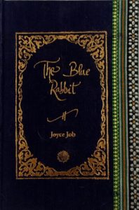 A sample cover of the book: navy blue coloured handloom sari with gold embossed nameplate and lettering for the title and author's name. The border of the sari lines the right hand margin of the cover.