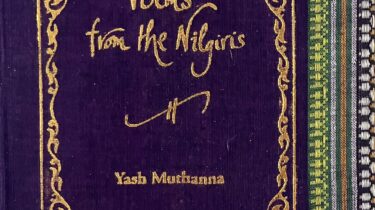 A sample cover of the book: dark purple coloured handloom sari with gold embossed nameplate and lettering for the title and author's name. The border of the sari lines the right hand margin of the cover.