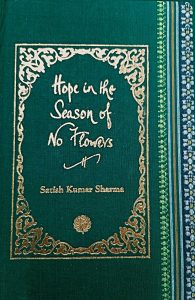 A sample cover of the book: jade-green handloom sari with gold embossed nameplate and lettering for the title and author's name. The border of the sari lines the right hand margin of the cover.