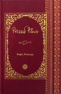 A sample cover of the book: red handloom sari with gold embossed nameplate and lettering for the title and author's name. The border of the sari lines the right hand margin of the cover.