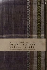 A sample cover of the book: dark purple handloom sari. The border of the sari lines the right hand margin of the cover. The title, author's name and genre of the book are printed on a white paper flap that is wrapped around a part of the lower half of the book.