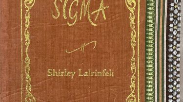 A sample cover of the book: ochre coloured handloom sari with gold embossed nameplate and lettering for the title and author's name. The border of the sari lines the right hand margin of the cover.