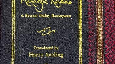 A sample cover of the book: black handloom sari with gold embossed nameplate and lettering for the title and author's name. The border of the sari lines the right hand margin of the cover.